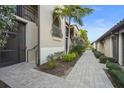 Exterior shot of the property showcasing well-maintained grounds, a paved walkway, and lush, tropical landscaping at 5527 Palmer Cir # 205, Bradenton, FL 34211