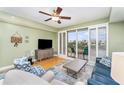 Comfortable living room featuring sliding glass doors to balcony, ceiling fan and stylish decor at 559 Bahia Beach Blvd, Ruskin, FL 33570