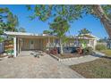 Single-story home with covered parking, landscaped front yard, and brick paver walkway to the front door at 5713 Saint Louis Ave, Sarasota, FL 34233