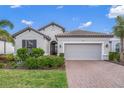 House exterior featuring a two-car garage and landscaped front yard at 5892 Semolino St, Nokomis, FL 34275