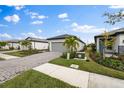 A home's exterior showcasing a paver driveway, landscaping, and a green lawn at 6240 Fish Eagle Ct, Nokomis, FL 34275