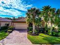 Single-Gathering home with a paved driveway and lush landscaping at 6814 Willowshire Way, Bradenton, FL 34212