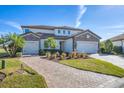 Two-story house with stone accents, three-car garage, and landscaped yard at 6868 Wild Lake Ter, Bradenton, FL 34212