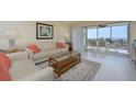 Cozy living room with comfortable seating, light color palette, and access to outdoor balcony with Gulf views at 757 Beach Rd # 300, Sarasota, FL 34242