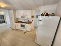 Bright kitchen with white cabinets and laminate flooring at 808 53Rd E Ave # 9, Bradenton, FL 34203