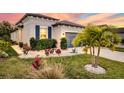 Landscaped front yard with palm trees and a two-car garage at 8501 Starlight Loop, Parrish, FL 34219