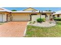 Front view of a condo with a brick driveway and well-manicured lawn at 96 Drifting Sands Dr, Venice, FL 34293