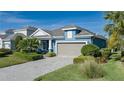 One-story home with blue siding, gray garage door, and landscaped yard at 10624 Falling Leaf Ct, Parrish, FL 34219