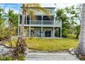 Two-story home with screened porch and grassy backyard at 115 Burns Rd, Terra Ceia, FL 34250