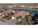 Aerial view of a house with a beautiful landscaped yard and a canal at 12563 Felice Dr, Venice, FL 34293