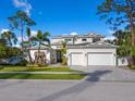 Beautiful two-story home featuring manicured lawn, mature palm trees, and a three-car garage at 1519 Harbor Dr, Sarasota, FL 34239