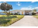 Inviting home exterior with a lush green lawn and covered carport at 1716 Forest Rd, Venice, FL 34293