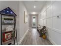 Long hallway with white wainscoting, wood-look tile floors, and bench at 1925 146Th E Ter, Parrish, FL 34219