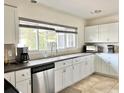 Bright kitchen featuring white cabinets, stainless steel appliances, and ample counter space at 2040 Pine Ridge Dr, Clearwater, FL 33763