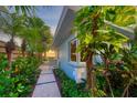 Landscaped side yard with a pathway leading to the house at 325 Casey Key Rd, Nokomis, FL 34275