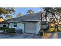 Attached garage with gray door and AC unit at 3401 Rochelle Ct # 131, Clearwater, FL 33761