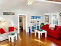 Living room with hardwood floors, red couch, and access to sunroom at 4019 Worcester Rd, Sarasota, FL 34231