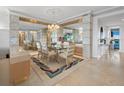 Elegant dining area featuring a glass table, chandelier, mirrored wall accents, and stylish rug at 415 L Ambiance Dr # C404, Longboat Key, FL 34228