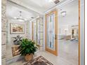 Bright foyer with decorative door, stone accents, mirror and a glimpse into the spacious living area at 415 L Ambiance Dr # C404, Longboat Key, FL 34228