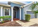 Front entrance with white columns, dark door, and brick walkway at 4360 85Th Avenue E Cir, Parrish, FL 34219