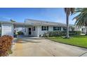 Well-maintained single-story home featuring a carport, manicured lawn, and mature landscaping at 4431 Independence Dr, Bradenton, FL 34210