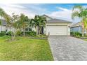 Front view of single-story home with paver driveway and landscaping at 4512 Renwick Dr, Parrish, FL 34219