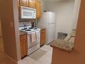 White appliances and granite countertops in this well-lit kitchen at 4751 Travini Cir # 4-108, Sarasota, FL 34235