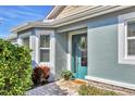 Inviting front entrance with teal door, stone accents, and lush landscaping at 5099 Flag St, Sarasota, FL 34232