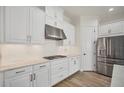 Modern white kitchen with stainless steel appliances and marble countertops at 5116 Tivoli Run, Bradenton, FL 34211