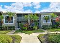 Another view of condo building, showcasing landscaping and walkway at 5211 Mahogany Run Ave # 124, Sarasota, FL 34241