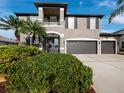 Two-story house with gray siding, three-car garage, and lush landscaping at 6150 42Nd Street E Cir, Bradenton, FL 34203