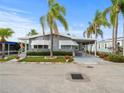 Gray manufactured home with carport, landscaping, and American flag at 62 Pelican S Dr, Oldsmar, FL 34677