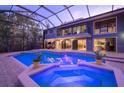 Inviting pool and spa with a screened enclosure, showing the house in the background at 716 Tropical Cir, Sarasota, FL 34242