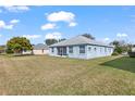 Back view of a one-story house, showcasing a screened patio and green lawn at 7432 39Th E Ct, Sarasota, FL 34243