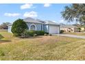 Landscaped yard with a one-story light blue house and driveway at 7432 39Th E Ct, Sarasota, FL 34243