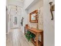 Bright entryway with wood console table, mirror, and decorative accents at 7876 Grande Shores Dr, Sarasota, FL 34240