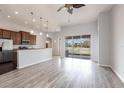 Bright open floor plan with wood floors, stainless appliances, and sliding glass doors to the backyard at 11715 Summer Springs Dr, Riverview, FL 33579