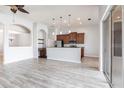 Open-concept living area with wood floors, modern lighting, and a breakfast bar overlooking the kitchen at 11715 Summer Springs Dr, Riverview, FL 33579