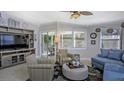 Living room with comfortable seating, a large TV, and access to a balcony at 1228 Siesta Bayside Dr # 1228-C, Sarasota, FL 34242