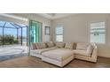Relaxing living space featuring a sectional sofa, sliding glass doors leading to a screened lanai, and wood-look flooring at 14155 Campfire Ct, Parrish, FL 34219