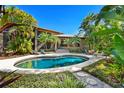Inviting kidney-shaped pool surrounded by tropical landscaping at 1804 N Lake Shore Dr, Sarasota, FL 34231