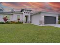 Front view of a house with a gray garage door and landscaping at 2219 Greenley Rd, North Port, FL 34286