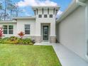 Modern front entrance with stone accents and a gray door at 2219 Greenley Rd, North Port, FL 34286