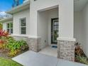 Close up of the front entrance with stone accents and gray door at 2219 Greenley Rd, North Port, FL 34286