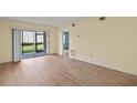 Living room with sliding glass doors and wood-look floors at 25100 Sandhill Blvd # 102, Punta Gorda, FL 33983