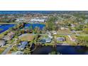 Aerial view of a waterfront home with stunning water views surrounded by lush greenery and other homes at 309 South Dr, Nokomis, FL 34275