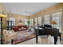 Bright living room featuring a grand piano and comfortable seating at 5521 Bilbao Pl, Sarasota, FL 34238