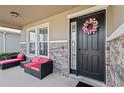 Front porch with black door and pink wreath, and two wicker armchairs at 6356 Mighty Eagle Way, Sarasota, FL 34241