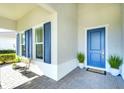Inviting front porch with blue door, shutters, and a tiled floor at 8066 Redonda Loop, Bradenton, FL 34202