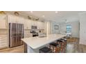 Modern kitchen with white cabinets, stainless steel appliances and an island with seating at 12607 Wheatgrass Ct, Parrish, FL 34219